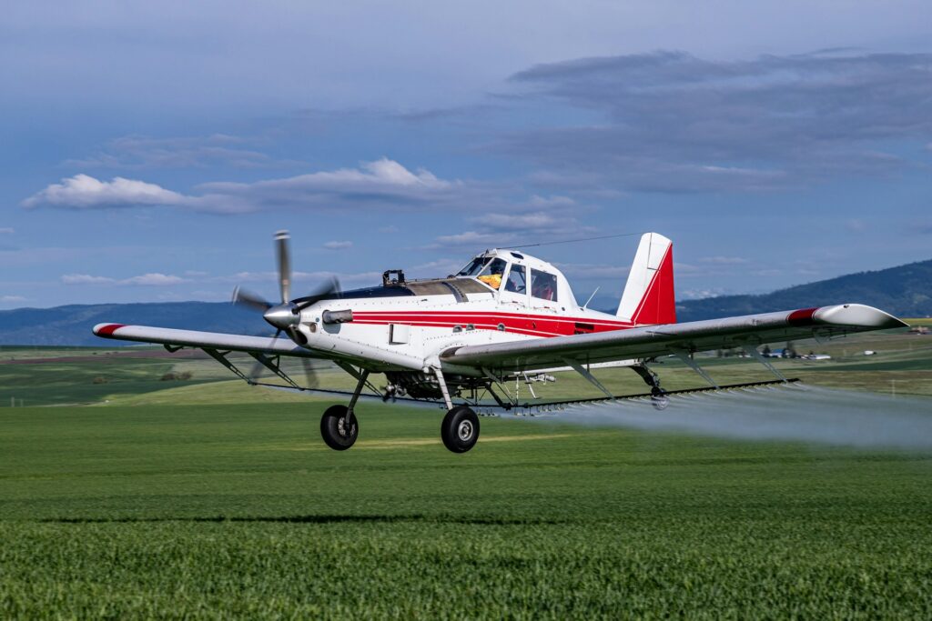 Pesticides in drinking water, A crop duster flying above crops, spreading pesticides and or herbicides.