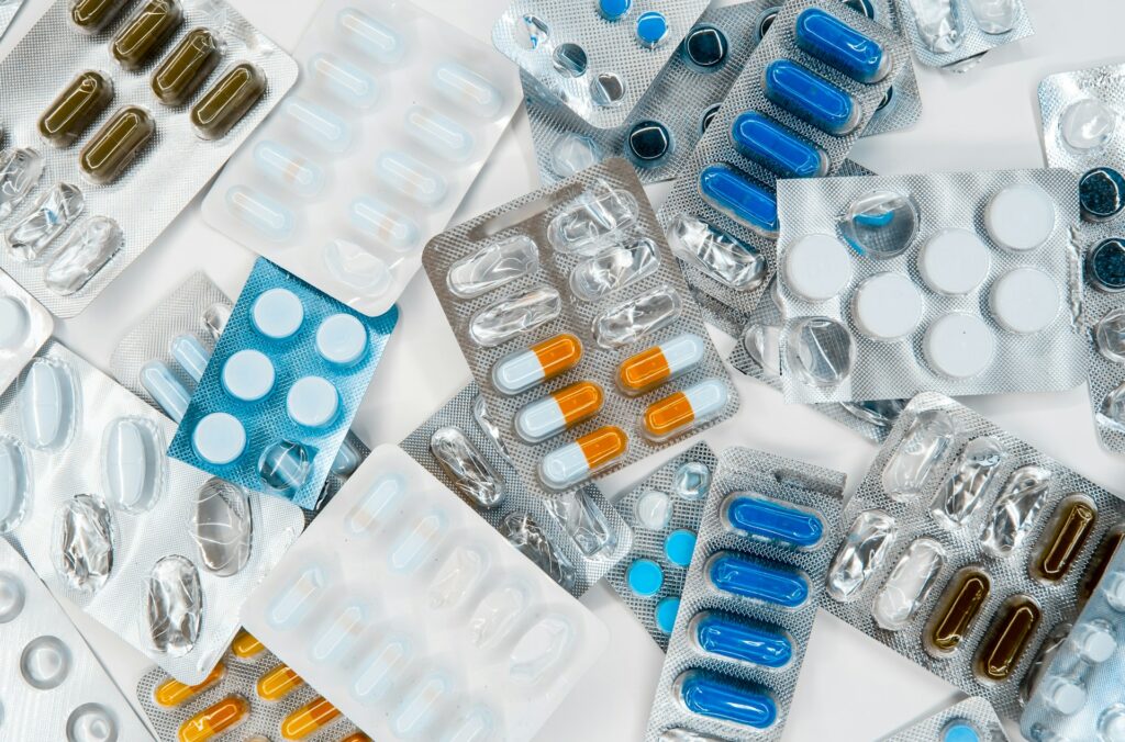 Pharmaceutical Contamination in Water, several different pharmaceutical pills laid out on a table in packaging